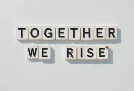 A vibrant display of letter tiles forming the phrase "Together We Rise" on a clean white background, symbolizing unity and motivation for personal and collective growth.の素材
