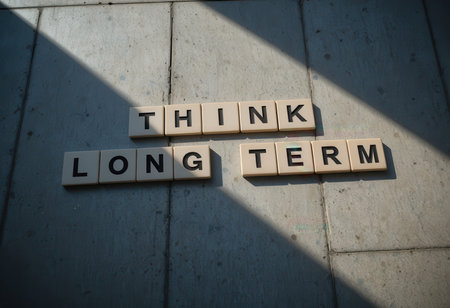 A captivating image featuring wooden tiles arranged with the phrase "Think Long Term," symbolizing strategic vision and mindful planning for future success and achievement.の素材