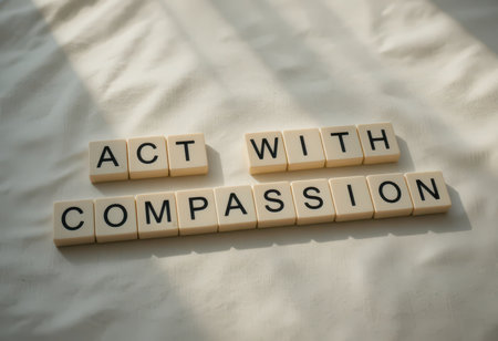 Inspirational message made with letter tiles against a soft background to convey the importance of compassion and kindness in daily life.の素材