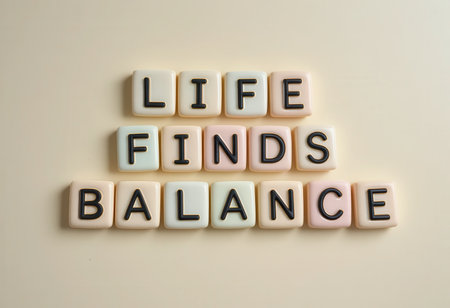 A creative arrangement of pastel letter tiles spelling "Life Finds Balance," symbolizing harmony and encouragement in personal growth and well-being.の素材