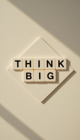 A creative flat lay of letter tiles spelling 'Think Big' against a light background. This image symbolizes motivation, positivity, and the pursuit of dreams. Perfect for inspirational content.の素材