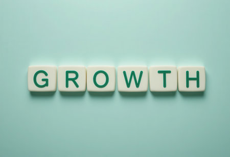A minimalistic composition featuring letter tiles spelling "GROWTH". This image symbolizes development, progress, and the journey towards achieving goals in various aspects of life or business.の素材
