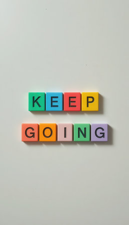 Colorful letter blocks form the motivational phrase "Keep Going," symbolizing perseverance and positivity. Ideal for inspirational themes in various creative projects.の素材