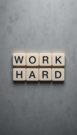 A motivational composition featuring the words "Work Hard" arranged in white tiles on a sleek marble background. Perfect for themes of ambition and success.の素材