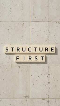 A minimalistic display featuring blocks arranged on a textured wall, conveying the phrase "Structure First". This image captures the essence of clarity and design.の素材
