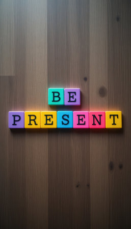 This image features vibrant blocks spelling out "Be Present" on a wooden surface, embodying a cheerful reminder of mindfulness and positivity in daily life.の素材