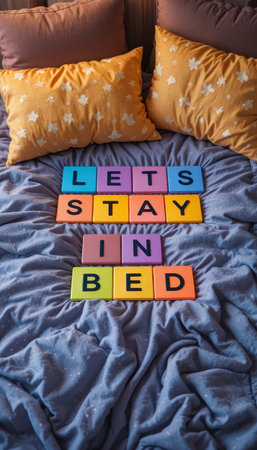 A cozy bed scene featuring colorful letter blocks spellingの素材