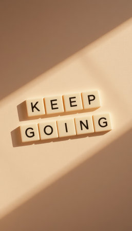 A captivating image featuring the words "KEEP GOING" displayed in a minimalist style, symbolizing encouragement and perseverance amidst soft, warm tones and gentle shadows.の素材
