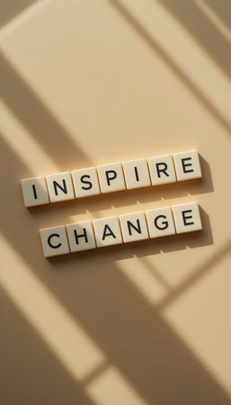 A serene flat lay image featuring the words "Inspire Change" crafted from individual letters on a soft cream surface, enhanced by gentle shadows and sunlight.の素材