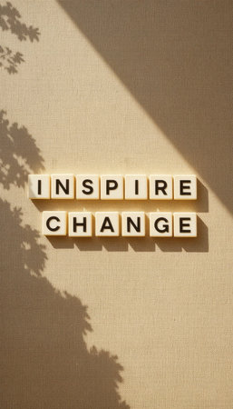 A simple yet powerful image featuring light and shadow play on a wall, with text blocks that spell out "Inspire Change," embodying motivation and creativity.の素材