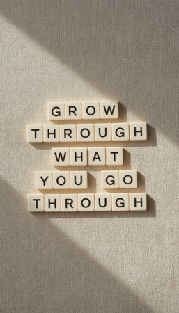 This image features a motivational quote arranged with letter tiles against a textured background. Ideal for themes of growth and resilience.の素材