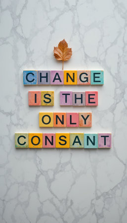 This vibrant image displays colorful letter blocks forming the message "Change is the Only Constant" paired with an autumn leaf, symbolizing growth and transformation.の素材