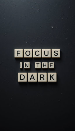 This image features the motivational phrase "Focus in the Dark" displayed on a dark background. The letters are arranged artistically to convey inspiration and determination.の素材
