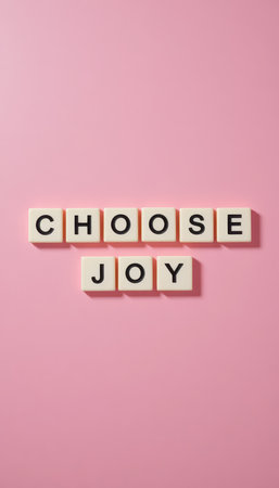 A cheerful arrangement of tiles spelling "Choose Joy" on a soft pink background. This inspiring composition embodies positivity and motivation, ideal for home decor.の素材