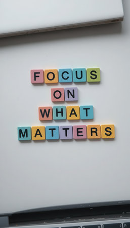 A flat lay composition featuring colorful letters spelling out "Focus on What Matters," ideal for themes of motivation, positivity, and personal development in a clean workspace.の素材