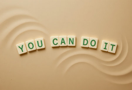 This image features a motivational phrase constructed with letter tiles on a smooth, neutral background. Perfect for inspiring creativity and positivity.の素材