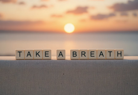 A serene sunrise scene featuring the inspiring message 'Take a Breath' crafted from letters, capturing a moment of tranquility by the ocean.の素材