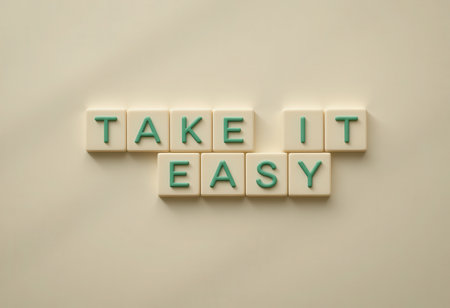 A creative composition featuring letter tiles spelling "Take It Easy" on a soft background. This image promotes relaxation and a positive mindset, perfect for wellness themes.の素材