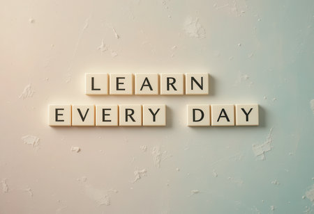Beautiful arrangement of letter tiles that promote the idea of daily learning and self-improvement. Perfect for educational themes and motivational content.の素材