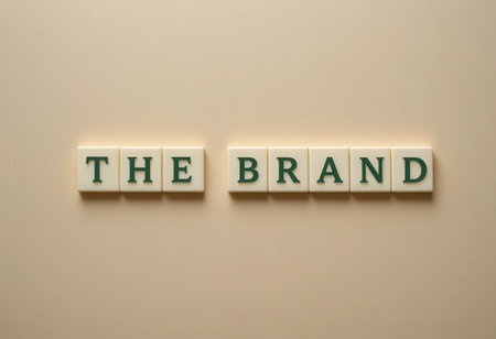 Individual letters are arranged to spell "THE BRAND" against a beige wall, making a clean and modern statement suitable for business or branding use.の素材