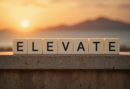 A captivating scene featuring blocks spelling "ELEVATE" against a stunning sunset backdrop. This image evokes emotions of motivation and inspiration, ideal for personal growth themes.の素材