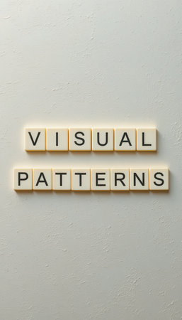 A close-up shot of letter tiles spelling "Visual Patterns" on a soft background, showcasing a creative concept in design and minimalism for artistic inspiration.の素材