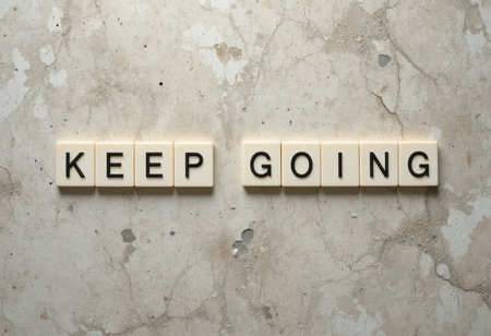 An inspiring message "Keep Going" displayed on a neutral background, perfect for promoting motivation and resilience in personal or professional settings.の素材