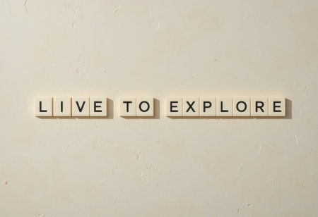 A striking composition featuring the phrase "Live to Explore" created with letter tiles against a smooth neutral wall. Perfect for inspiring adventure and creativity.の素材