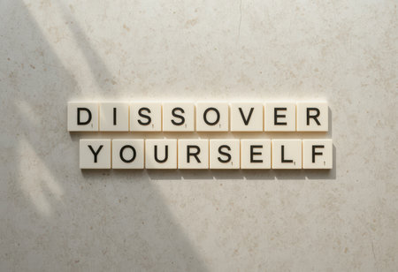 A creative arrangement of letter tiles spelling "Discover Yourself" on a soft, neutral surface, inspiring introspection and personal growth. Perfect for motivational themes.の素材