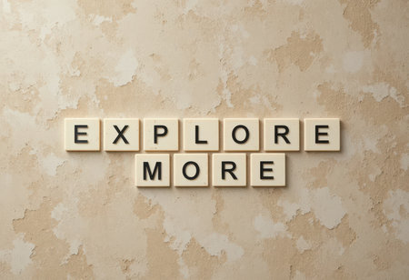 A motivational composition featuring wooden letter tiles that spell "Explore More" against a soft beige background, perfect for inspiring creativity and adventure.の素材