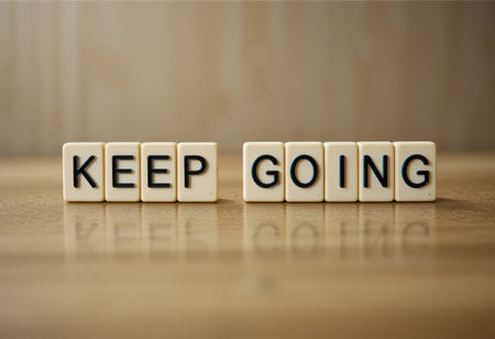 The image captures a motivational message formed with letter tiles that read "KEEP GOING." This arrangement symbolizes encouragement and determination in overcoming challenges.の素材