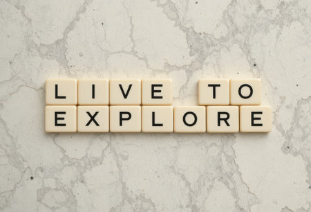 This image features the motivational phrase "Live to Explore" arranged in clear tiles on a marble background, ideal for inspiring creativity and positivity.の素材