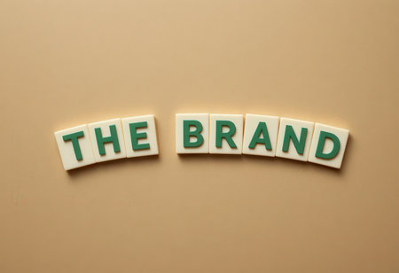 Eye-catching arrangement of letter tiles spelling "The Brand" on a neutral surface, perfect for themes of branding and marketing in modern graphics.の素材