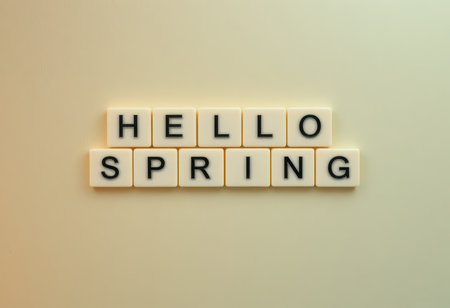 A charming arrangement of letter tiles spelling "Hello Spring" on a gentle background, perfect for seasonal decor or a vibrant greeting.の素材