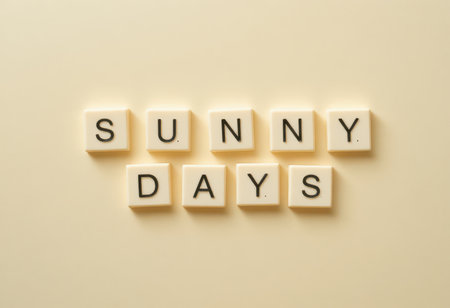 This image features tile letters arranged to spell "Sunny Days" against a soft beige background, evoking a sense of warmth and positivity perfect for various creative projects.の素材