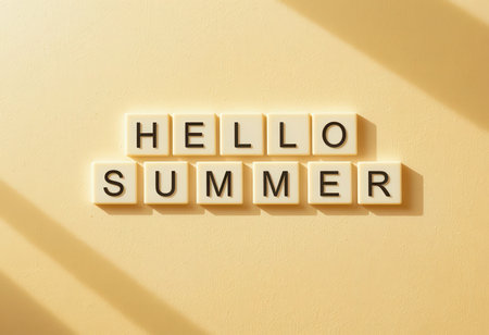 A bright and cheerful 'Hello Summer' message displayed with letter tiles on a soft yellow background. The warm colors evoke a sunny and joyful feeling perfect for summer.の素材