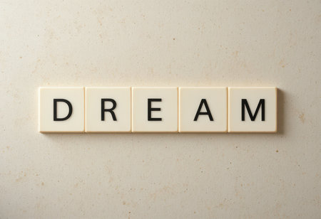 The image showcases the word "DREAM" composed of simple letter tiles against a light background, symbolizing hope and aspiration.の素材
