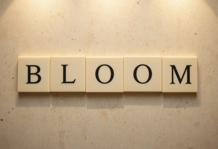 This image features the word "BLOOM" elegantly displayed in a minimalist style against a cream stone background, illuminated by soft lighting.の素材
