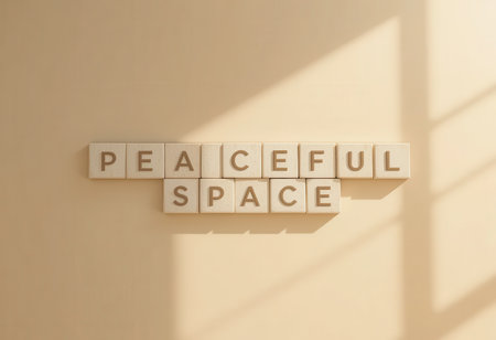A serene arrangement of wooden letters spelling "Peaceful Space" on a minimalist beige wall. Sunlight creates gentle shadows, enhancing calm and tranquility.の素材