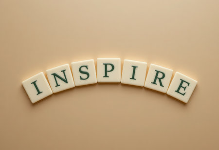 The word "Inspire" is formed using letter tiles against a warm beige background. This image symbolizes motivation and encouragement, suitable for various creative projects.の素材