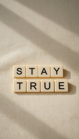 A serene composition featuring letter tiles arranged to spell 'Stay True', highlighted by gentle natural light and soft shadows, evoking inspiration and motivation.の素材