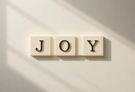 A minimalist display of letter tiles spelling the word "JOY." Soft shadows add depth to the composition, creating a warm and inviting atmosphere. Perfect for inspiring positivity and happiness in any space.の素材