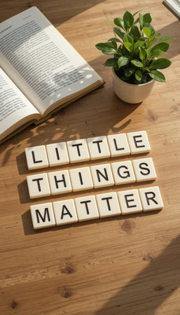 A warm and inviting scene featuring the phrase "Little Things Matter" on a wooden table, accompanied by a small plant and an open book, perfect for promoting positivity.の素材