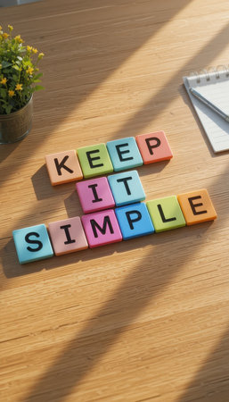 A vibrant arrangement of colorful building blocks spells "Keep It Simple" on a wooden desk. The image captures a bright and inspiring workspace perfect for motivational themes.の素材