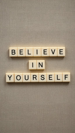 Close-up view of letter tiles arranged to spell "Believe in Yourself" on a textured background, symbolizing motivation and self-empowerment. Perfect for inspirational themes.の素材
