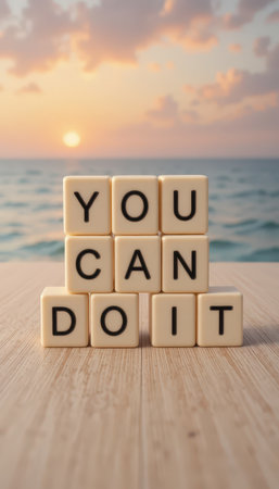 A serene beach scene at sunset featuring wooden blocks arranged to spell "YOU CAN DO IT." This image embodies positivity, motivation, and the beauty of nature.の素材