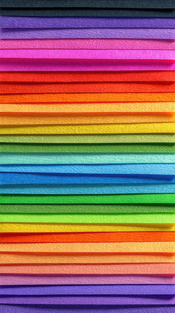 A vibrant display of textured paper rolls arranged in a rainbow gradient. Perfect for arts and crafts, design projects, and creative workspaces, showcasing bright colors and textures.の素材