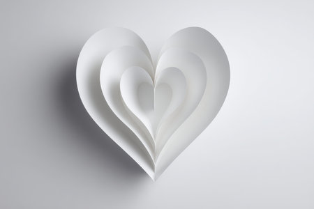 This artistic image features elegant layers of white paper forming a heart, set against a soft gray background, perfect for themes of love and romance.の素材