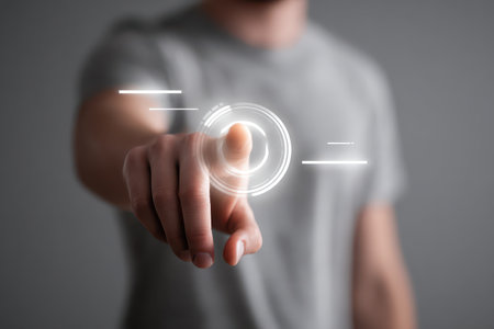 A young man interacts with a virtual interface by touching it with his finger. The image showcases futuristic technology and digital engagement in a minimalistic setting.の素材