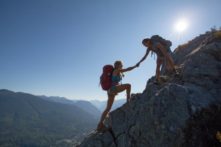 A dynamic scene of two climbers ascending a rocky mountain, showcasing teamwork and adventure. The beautiful landscape emphasizes the thrill of exploring nature.の素材